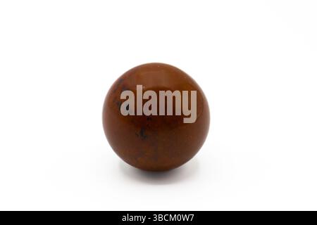 Pietra ossidiana di mogano su sfondo bianco. L'ossidiana di mogano è apprezzata per le sue proprietà energetiche e terapeutiche. Foto Stock