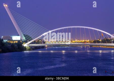 I ponti illuminati Barqueta e Alamillo esaltano lo skyline di Siviglia, mostrando eleganza e serenità al crepuscolo. Foto Stock