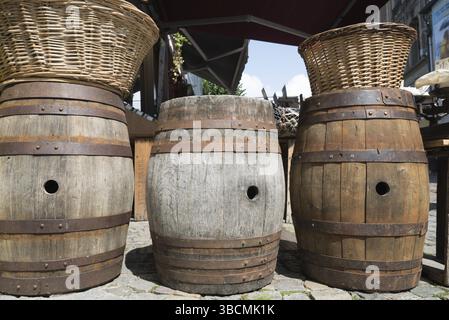 Francia - 15 agosto 2019: Vecchie botti di sidro di legno vuote utilizzate come tavoli da bar e articoli decorativi Foto Stock