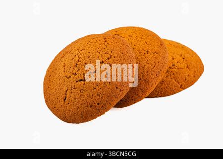 Tre biscotti allo zenzero spessi sono posizionati a stretto contatto su una superficie bianca pulita, evidenziandone la consistenza e l'invitante esterno marrone, perfetto per Foto Stock