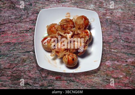 Takoyaki servito su un piatto Foto Stock