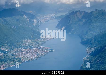 Paesaggio aereo con il villaggio di Mandello del Lario sul lago di Como, a nord, girato da un aereo aliante con luce brillante primaverile, Lombardia, Italia Foto Stock
