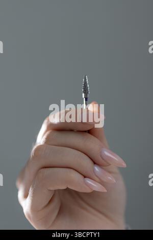 Gli strumenti di manicure sono a portata di mano per lavorare su una bella manicure beige, primo piano di un salone. Foto Stock