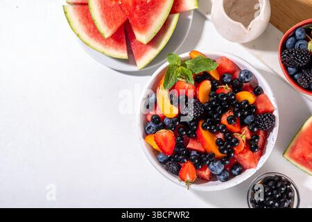 Insalata estiva di frutti di bosco con perle di tapioca. Sana insalata di rinfresco con anguria, fragole, mirtilli e palline da tè con bollicine, su scheda bianca Foto Stock