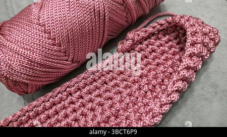 Elementi per maglieria di una borsa rosa da donna, maglieria a mano con manico lungo. Istruzioni dettagliate. Su sfondo grigio. Foto Stock