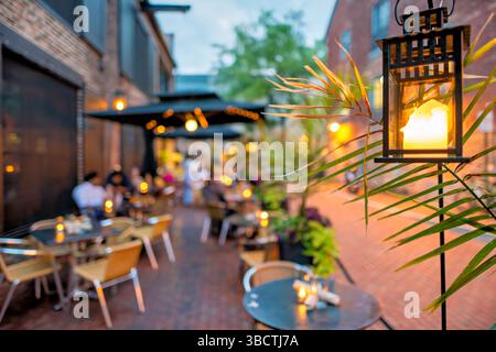 Virtue Feed and Grain Restaurant posti a sedere all'aperto Alexandria Virginia // ALEXANDRIA, Virginia - posti a sedere all'aperto al Virtue Feed and Grain Restaurant nel quartiere storico di Old Town Alexandria. Il ristorante, ospitato in un magazzino ristrutturato del XIX secolo che un tempo serviva come negozio di alimenti e cereali, offre ai clienti opzioni per mangiare all'aperto. Situato a solo un isolato dal lungomare del fiume Potomac al 106 di South Union Street, lo spazio all'aperto consente ai commensali di gustare i pasti mentre si sperimenta il fascino storico della città vecchia di Alexandria. Foto Stock