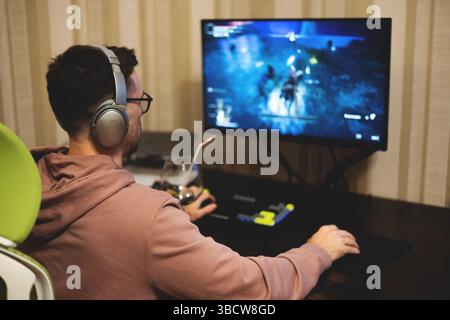 Giovane che gioca a un videogame per computer Foto Stock