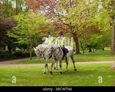 Agenti della polizia metropolitana a cavallo che attraversano Hyde Park nel centro di Londra, Regno Unito Foto Stock