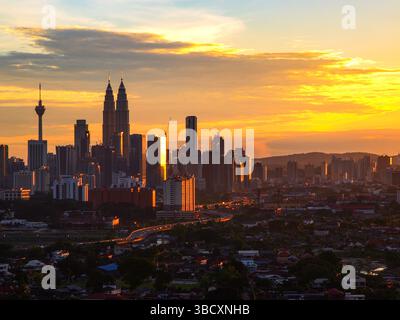 Paesaggio urbano di Kuala Lumpur prima del tramonto con sfumature arancioni. Foto Stock