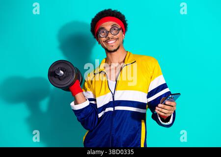 Vivace uomo afroamericano in retro Sportswear Weightlifting in uno stile giocoso Foto Stock