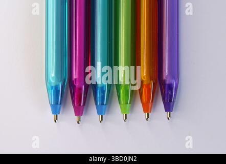 Penne blu, rosa, verde, arancione e viola su sfondo bianco Foto Stock