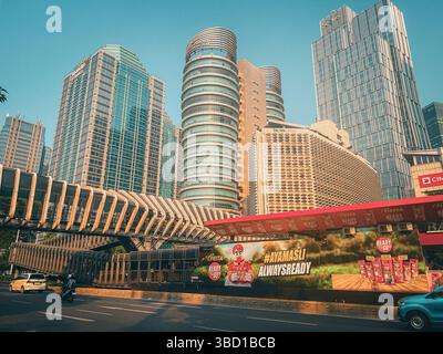 Giacarta, Indonesia - agosto 2024: Moderno paesaggio urbano di Giacarta con Sequis Tower, futuristico ponte pedonale (JPO) nei distretti SCBD. Foto Stock