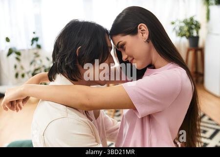 Una coppia gode di un momento intimo pieno di affetto e calore nel proprio soggiorno. Foto Stock