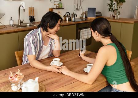 La coppia gode di una connessione intima con il caffè mentre condivide i momenti nella sua calda cucina. Foto Stock
