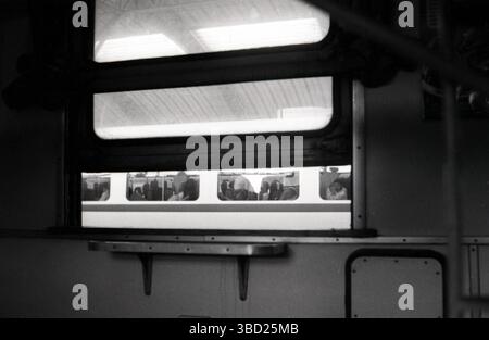 Film in bianco e nero degli anni '2010 girato ai pendolari attraverso la finestra del treno alla stazione ferroviaria cinese Foto Stock