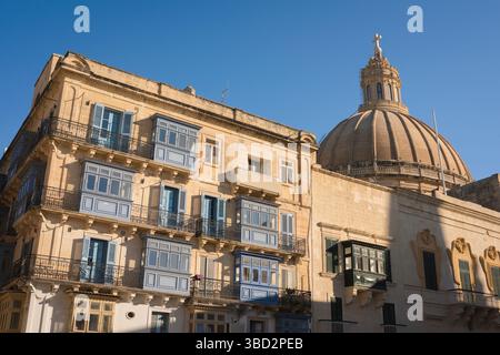 Via la Valletta, dettaglio di un edificio a la Valletta con file di balconi chiusi tipici dell'architettura del centro della città, Malta Foto Stock