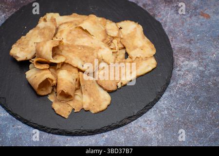 Seitan: Alternativa di carne vegana fatta con glutine di frumento vitale, tagliata su tavola di ardesia Foto Stock