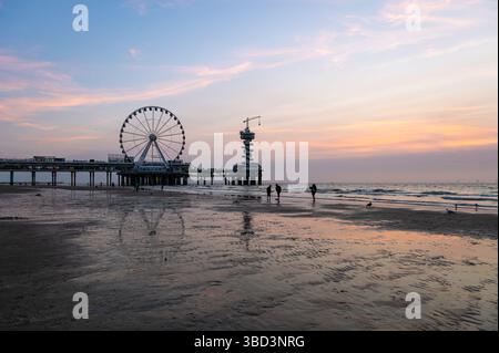 L'Aia, Paesi Bassi - 18 agosto 2024: Vista del tramonto con la ruota panoramica sulla spiaggia di Scheveningen, l'Aia Foto Stock