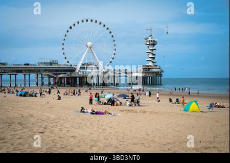 L'Aia, Paesi Bassi - 18 agosto 2024: Turisti alla ruota panoramica sulla spiaggia di Scheveningen, l'Aia Foto Stock