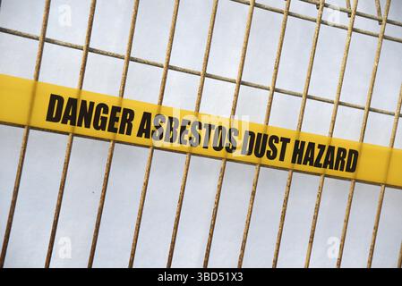 Nastro di pericolo amianto disposto intorno a un cantiere edile Foto Stock