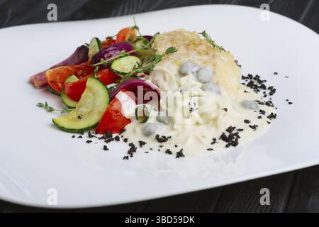 Filetto di pesce con verdure grigliate sotto salsa panna Foto Stock