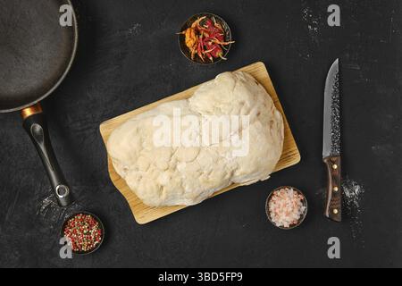 Vista dall'alto della coda di grasso di agnello sul tavolo da cucina con sale e pepe Foto Stock