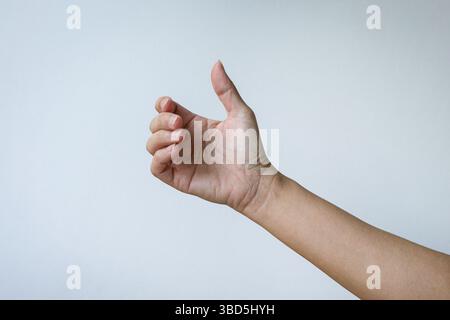 Mano di una donna che tiene un telefono invisibile o un gesto di un oggetto. Isolato su sfondo bianco. Foto Stock