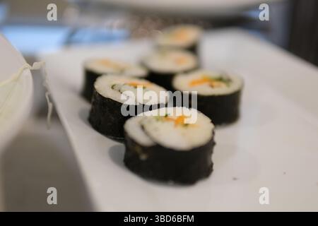 Involtino di riso ripieno di carote, salsiccia, ravanello e uova. Rotoli di kimbap coreani Foto Stock