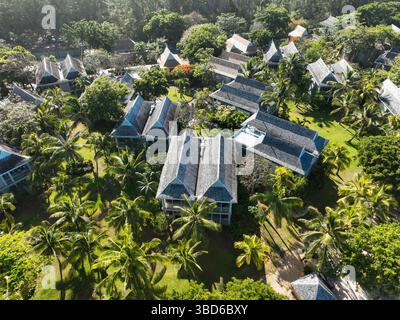 Vista aerea delle ville in stile tropicale con tetti a spiovente tra fitte palme a le Morne Foto Stock