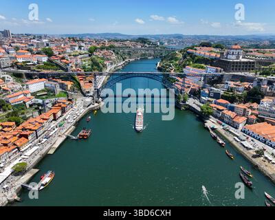 Foto aerea di una barca che naviga sotto il ponte Dom Luís i di Porto Foto Stock