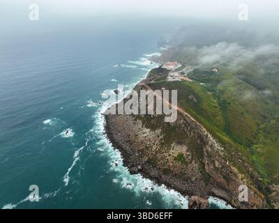 Vista aerea della costa frastagliata e dei sentieri di scogliera che svaniscono nella nebbia oceanica Foto Stock