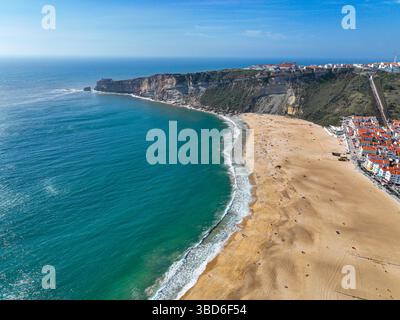 Vista aerea della vasta spiaggia, del porto e dell'orizzonte Atlantico di Nazare Foto Stock