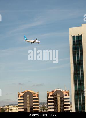 Almada, Portogallo - 12 maggio 2024: Aereo passeggeri Air Europa che vola sopra i moderni edifici della città sotto il cielo limpido Foto Stock
