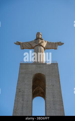 Almada, Portogallo - 12 maggio 2024: Vista frontale del monumento Cristo Rei sotto un cielo azzurro Foto Stock