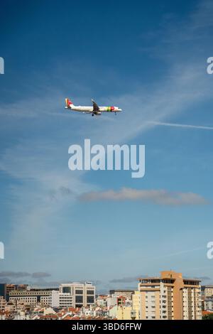 Almada, Portogallo - 12 maggio 2024: Aeroplano TAP che vola sopra il paesaggio urbano durante l'atterraggio Foto Stock