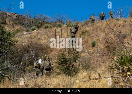 Soldati statunitensi, assegnati alla 76th Engineer Company, 41st Engineer Battalion, sotto Joint Task Force–Southern Border, attraversano terreni ripidi trasportando equipaggiamenti durante una missione di messa in deposito di segni della New Mexico National Defense area (NMNDA) vicino ad Antelope Wells, New Mexico, 20 maggio 2025. Sotto la direzione del Northern Command degli Stati Uniti, la Joint Task Force–Southern Border allinea gli sforzi per sigillare il confine meridionale e respingere le attività illegali ed è responsabile di operazioni su larga scala, agili e di tutti i domini, che consentiranno operazioni DoD più efficaci ed efficienti. (Foto U.S. Army di SPC. Anjelica ASE Foto Stock