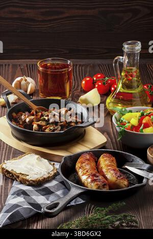 Funghi fritti e uova in una padella di ghisa. Ingredienti per una colazione rustica su un tavolo di legno Foto Stock
