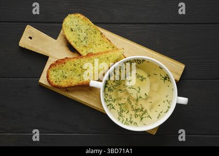 Vista dall'alto del brodo di pollo con uova e aglio croccante pane tostato su tavola di legno Foto Stock