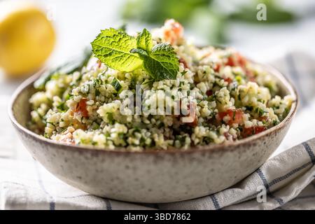 Insalata tradizionale di Tabouleh con bulgur, prezzemolo, cetrioli, pomodoro, coriandolo, aglio, menta e altri ingredienti. Foto Stock