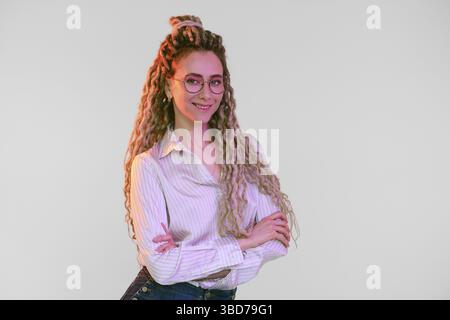 Giovane donna con dreadlock incrociate le mani sul petto Foto Stock