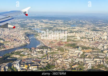 Vista aerea obliqua dalla finestra dell'aereo sopra la città di Porto, Portogallo, punta europea dell'ala dell'aereo visibile Foto Stock