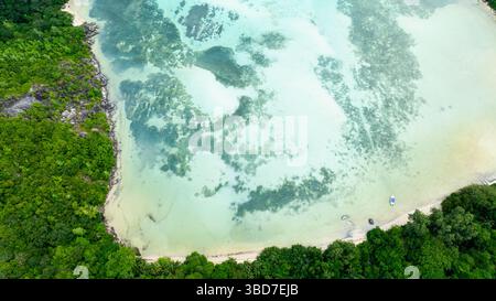 Il terreno montuoso incontra l'oceano cristallino in un paesaggio mozzafiato. Seychelles, Mahe. Foto Stock