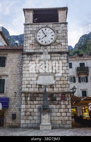 La Torre dell'Orologio risale al 1602, con la gogna ricostruita sulla Piazza delle armi della città vecchia nella città costiera di Cattaro, situata nella baia di Cattaro, in Montenegro Foto Stock