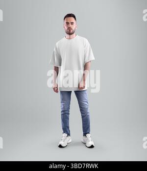 Mockup di t-shirt oversize bianca su uomo con barba in jeans blu, sneakers, vista frontale, isolata sullo sfondo in studio. Modello di un shi maschile alla moda Foto Stock