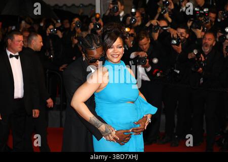 19 maggio 2025, Cannes, Francia: A$AP ROCKY, 36, sul tappeto piovoso cullando il suo boo RIHANNA, 37 anni, pancia, con il mento appoggiato sulla spalla sulla "la montée des Marches". La cantante, attrice e donna d'affari Barbadian Billionaire incinta, ha mostrato il suo piccolo bump in crescita con un abito blu elettrico con aperture strategiche e una cravatta al collo e il suo partner di stile rapper americano che indossa un vestito nero, Ray-Bans nero e un set completo di grillz alla prima del film diretto da Spike Premiere di 'Higher 2 Lower', in cui è co-protagonista insieme a Denzel. Lunedì 7° giorno del 78° anno C Foto Stock