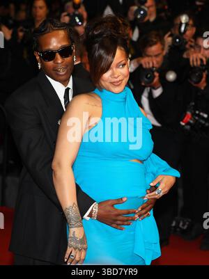 19 maggio 2025, Cannes, Francia: A$AP ROCKY, 36, sul tappeto piovoso cullando il suo boo RIHANNA, 37 anni, pancia, con il mento appoggiato sulla spalla sulla "la montée des Marches". La cantante, attrice e donna d'affari Barbadian Billionaire incinta, ha mostrato il suo piccolo bump in crescita con un abito blu elettrico con aperture strategiche e una cravatta al collo e il suo partner di stile rapper americano che indossa un vestito nero, Ray-Bans nero e un set completo di grillz alla prima del film diretto da Spike Premiere di 'Higher 2 Lower', in cui è co-protagonista insieme a Denzel. Lunedì 7° giorno del 78° anno C Foto Stock