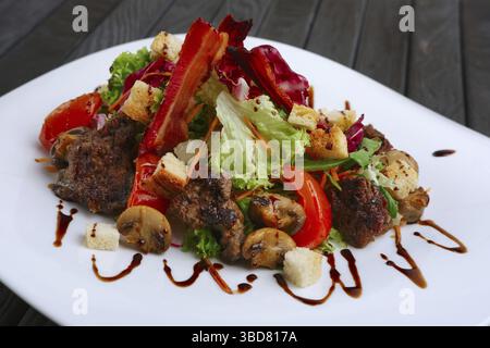 Con insalata di fegato, bacon, grigliate di pomodoro e pepe con cavolo rosso e funghi Foto Stock