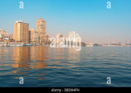 Lo skyline della città del Cairo si riflette sul fiume Nilo durante una giornata limpida nel cuore dell'Egitto Foto Stock