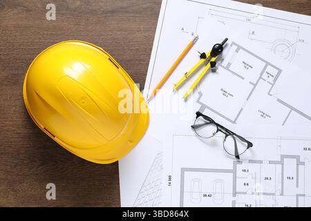 Diversi disegni architettonici, elmetto, matita, divisore e vetri su tavolo in legno, piatto Foto Stock