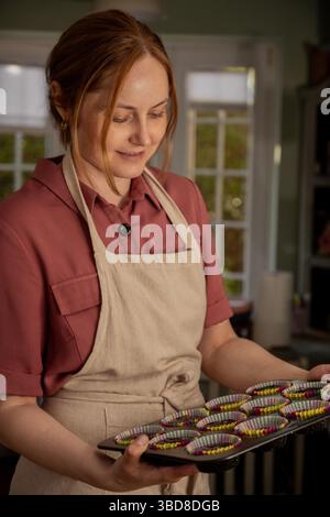 Donna con vassoio per cupcake crudi Foto Stock